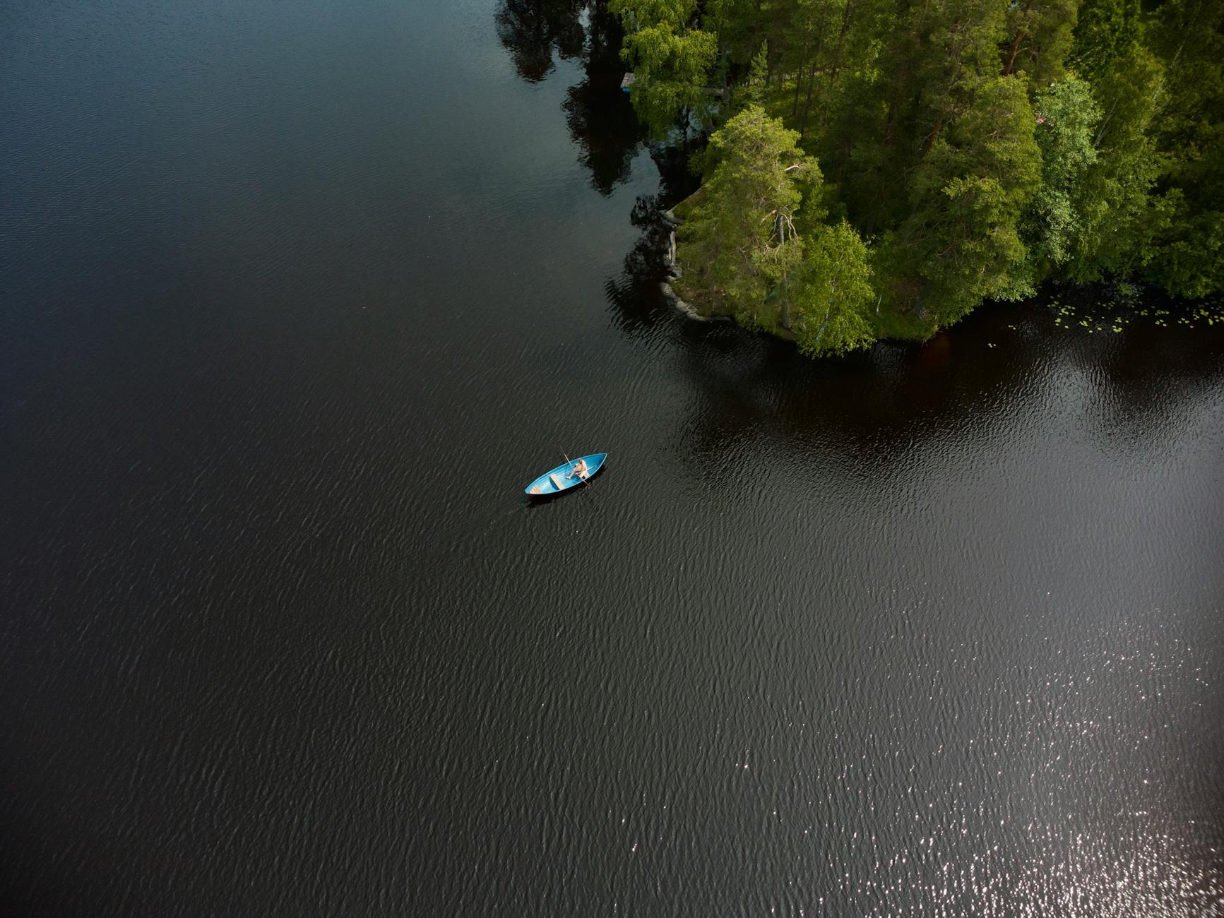 Kajak na spokojnym fińskim jeziorze otoczonym zielonym lasem