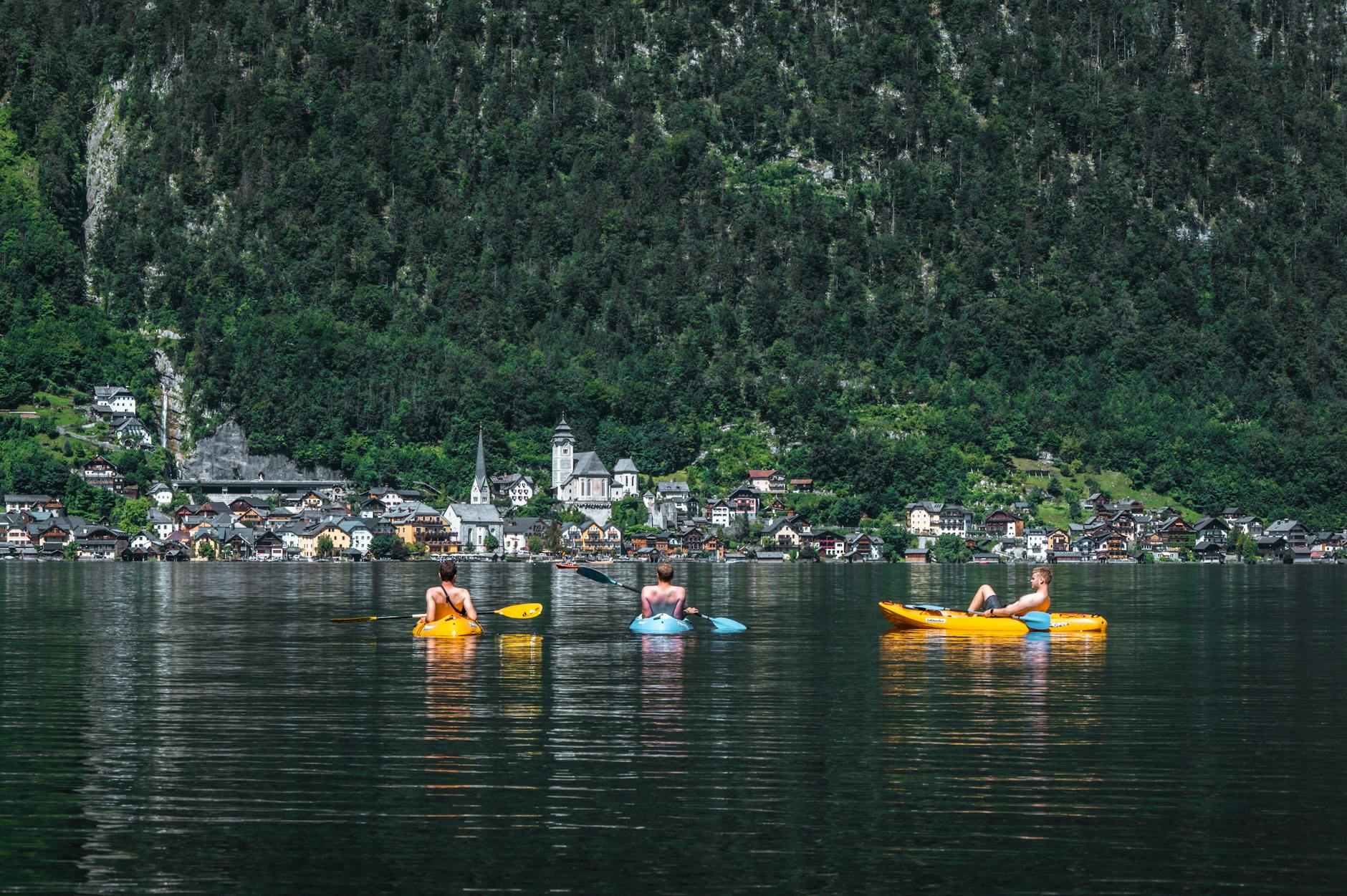 Kajakarze na jeziorze z fińską wioską i górami w tle