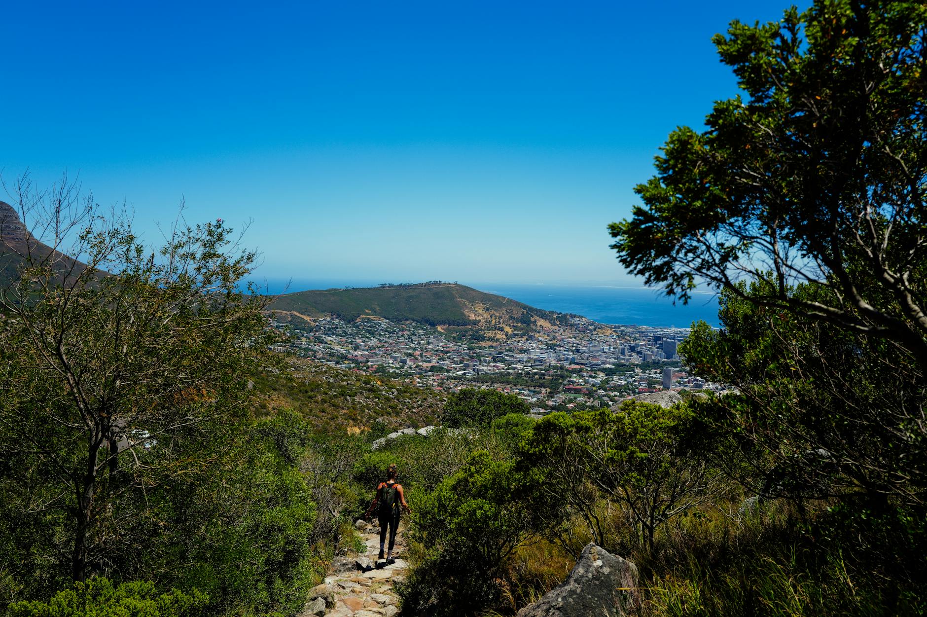 Turysta z plecakiem na szlaku z widokiem na Kapsztad i ocean
