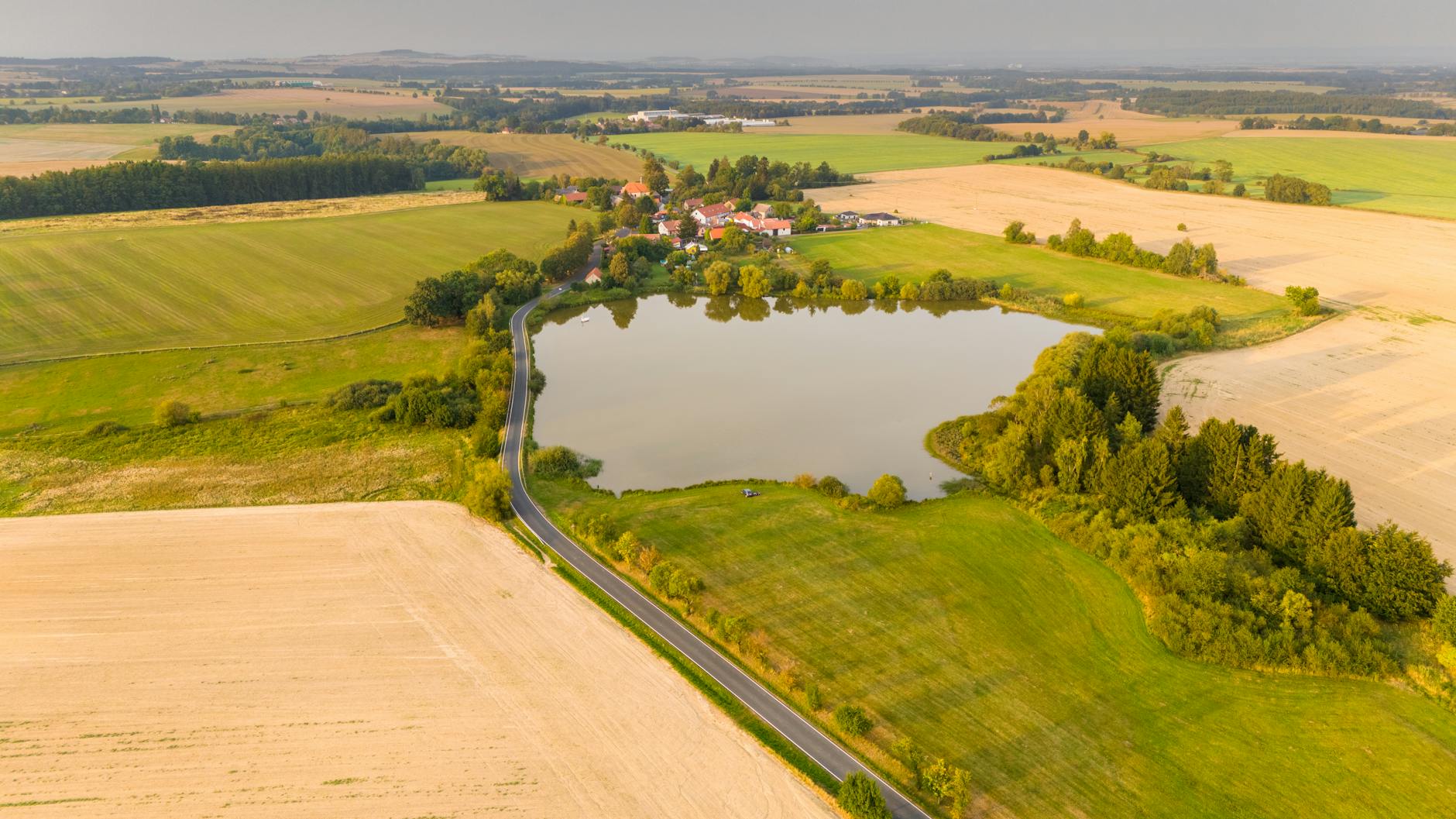 Zbraslavice z lotu ptaka: pola uprawne i jezioro w czeskiej wsi