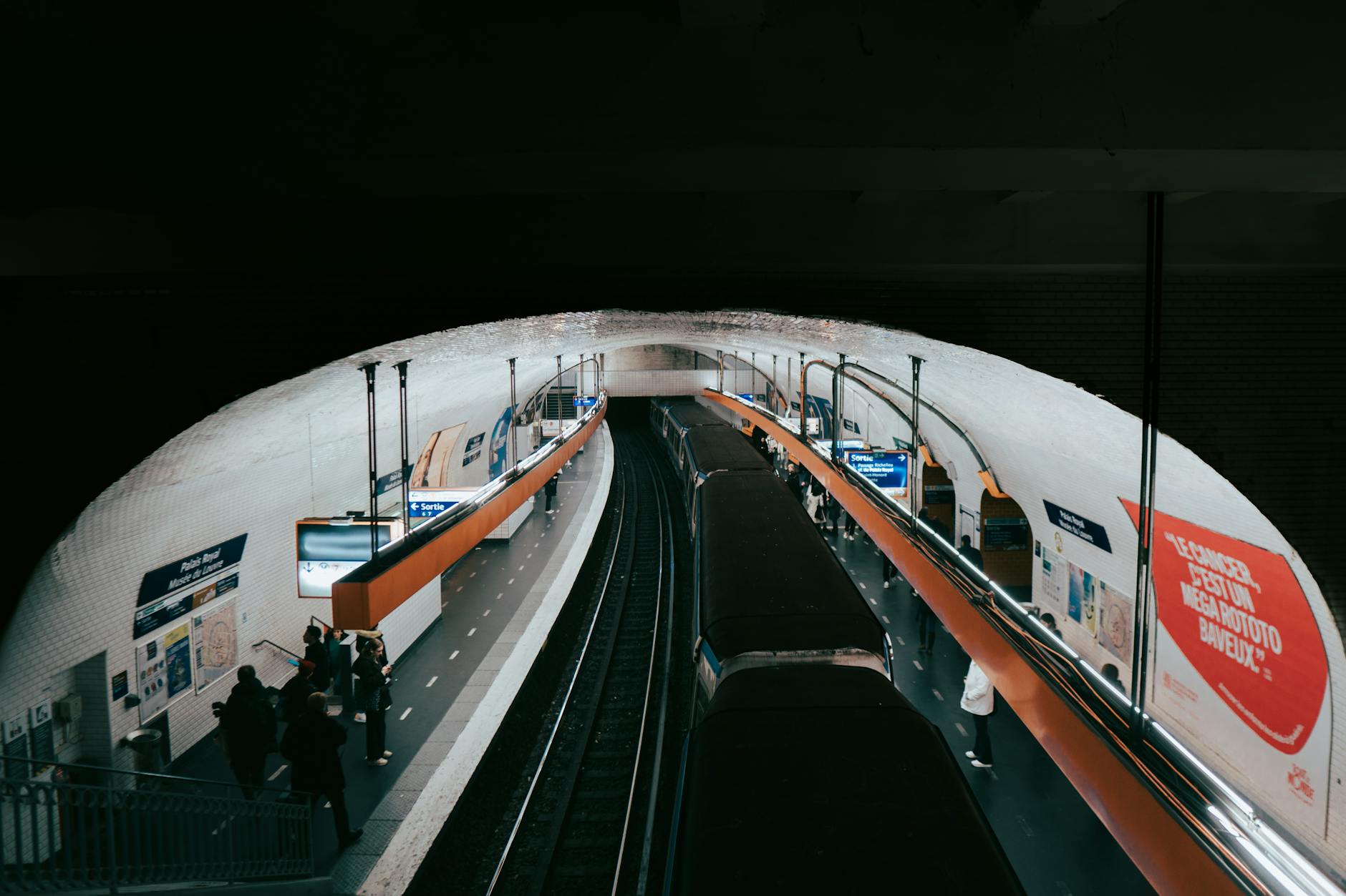 Pasażerowie czekający na metro na zatłoczonej stacji w Paryżu